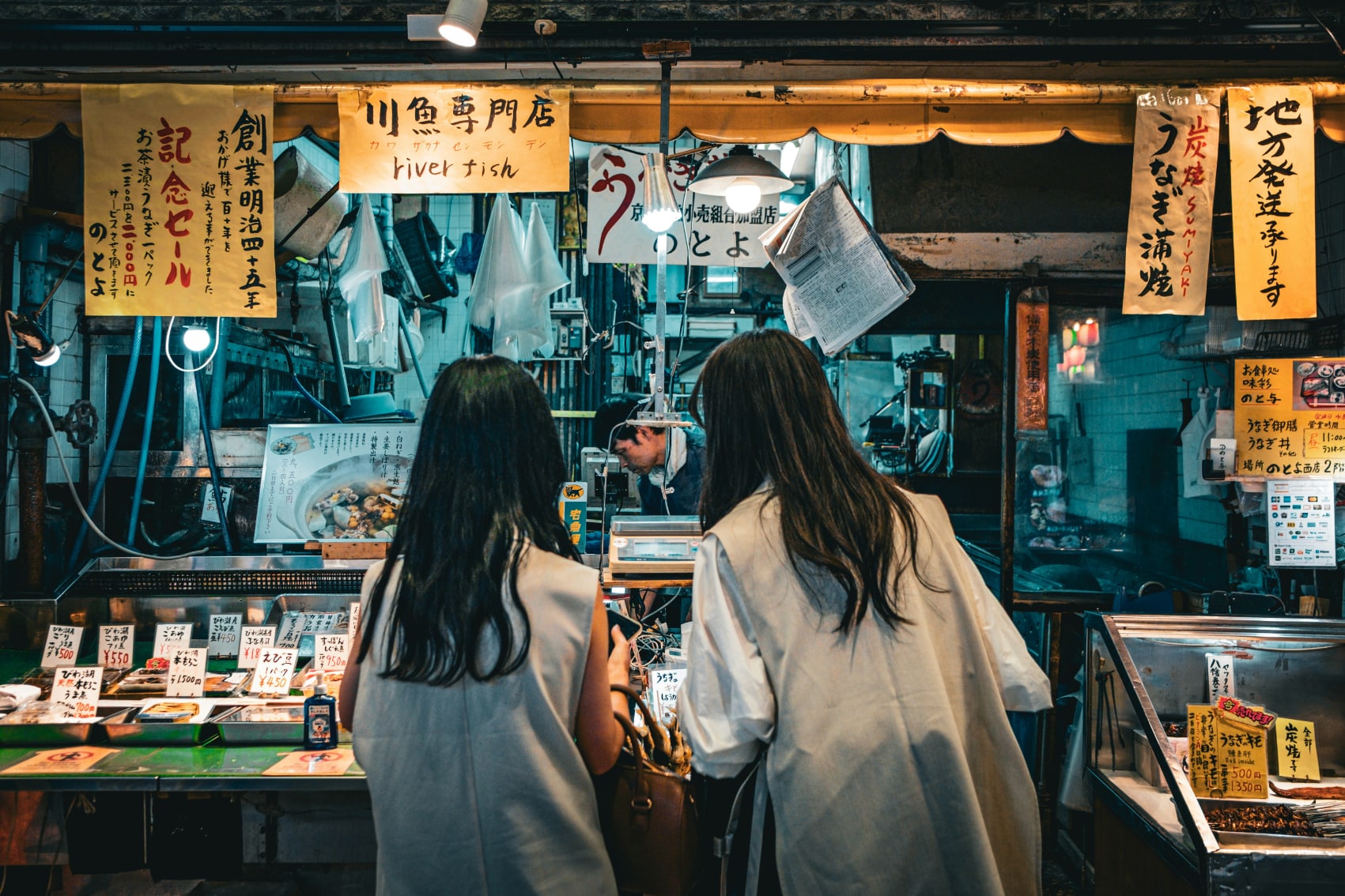 Sushi stall two girls look over the sushi options at a stall